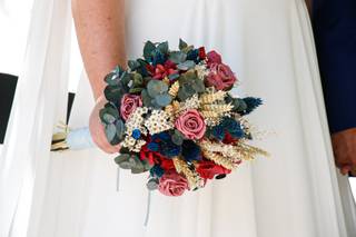 Chica sujeta un ramo de novia multicolor con margaritas y rosas, entre otras flores