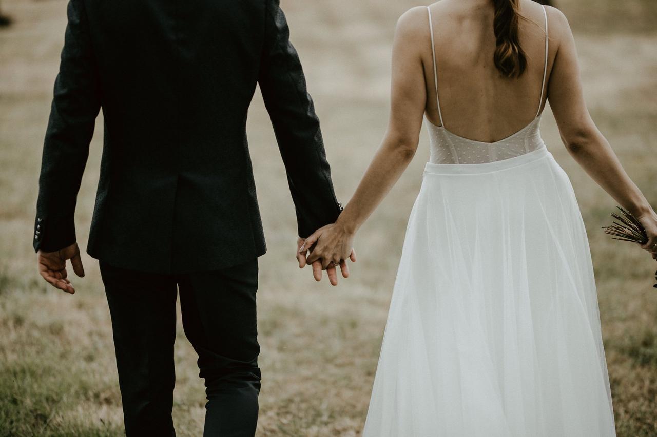 pareja de novios de espalda al aire libre durante la sesión fotográfica del día de la boda
