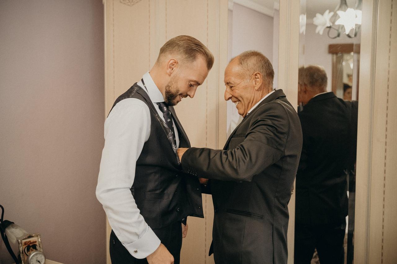 Fotos de padres imprescindibles en la boda: padre ayudando al novio a vestir