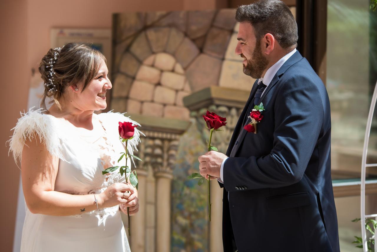 Ritual boda: pareja de chico y chica durante la ceremonia de la rosa en su boda civil al aire libre