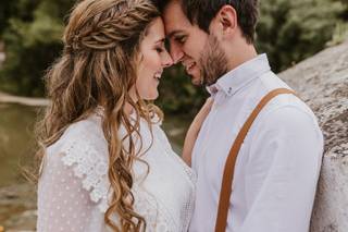 Hombre y mujer con postura de complicidad vestidos de boda