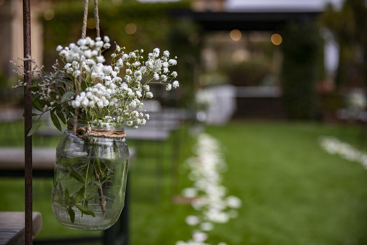 Flores para boda: jarrón colgando del lateral de una silla con un ramillete de paniculata en su interior