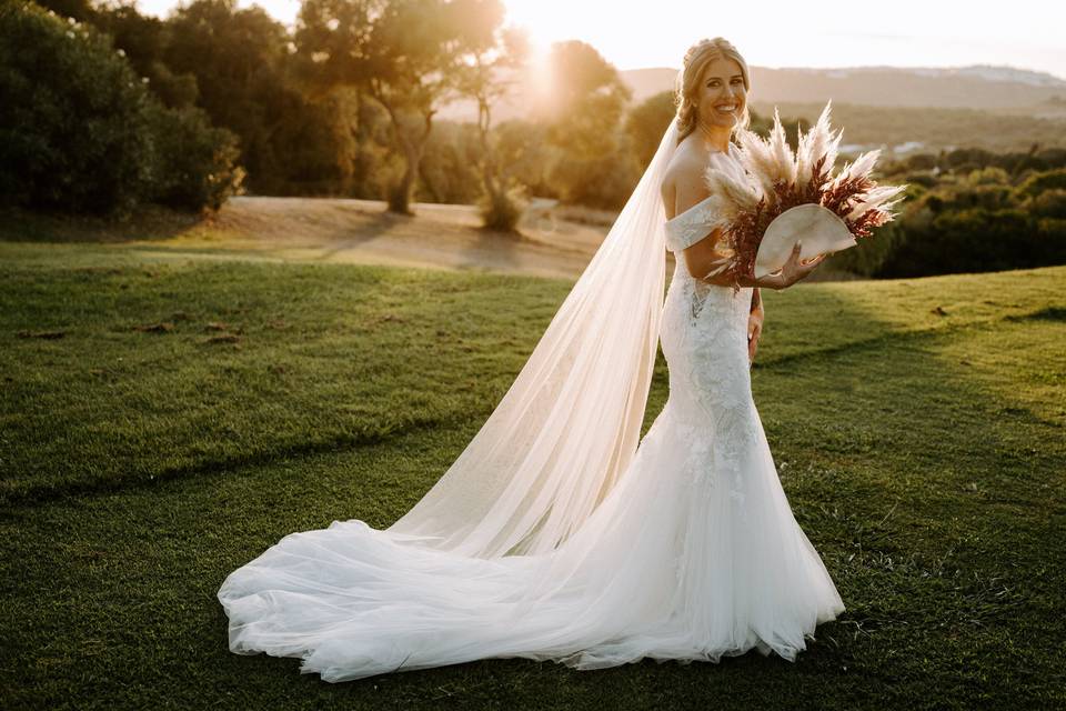 Tipos de vestidos de novia: novia con un traje sirena y un original ramo de flores