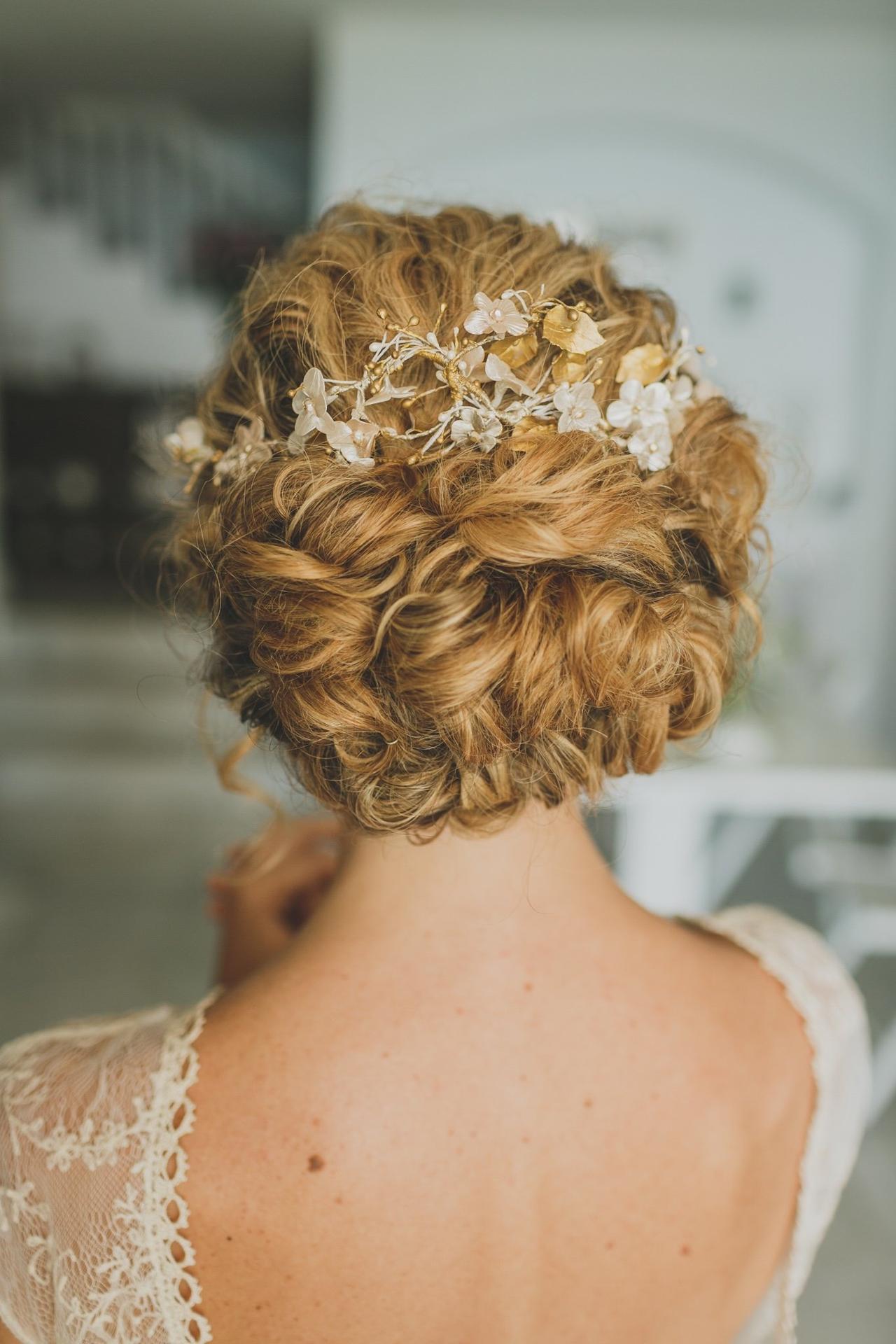 Moño de novia con pelo rizado y tocado de porcelana