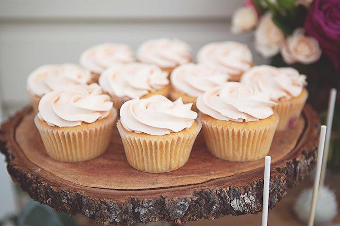 Cupcakes en Peach Fuzz sobre una base de tronco de madera