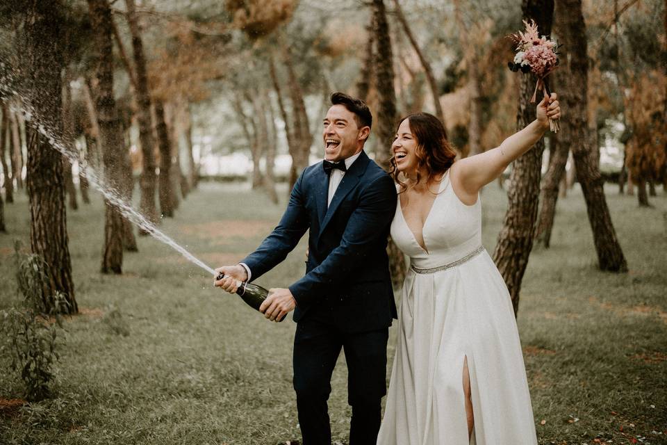 pareja de novios celebrando con cava la felicidad por haberse casado