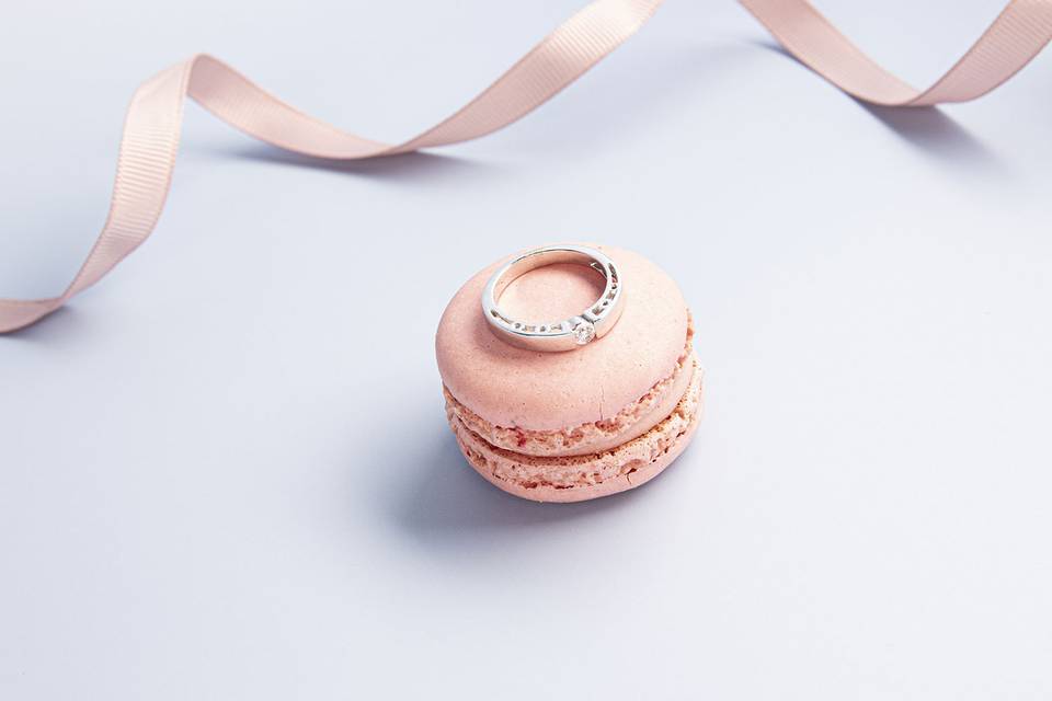 Fotografía del anillo de compromiso sobre un macaron antes del día de la boda