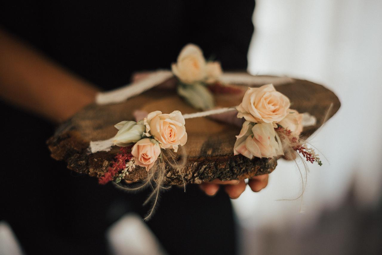 Base con varios prendidos de novio con rosas