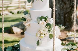 Tarta de boda de varios pisos con motivos naturales en un columpio de madera