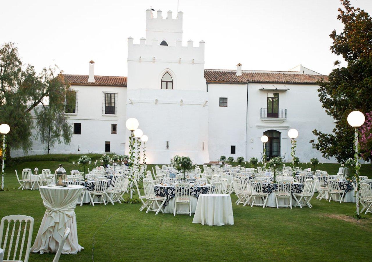 Cortijo Torre de la Reina: jardín junto al edificio preparado para un banquete de boda al aire libre