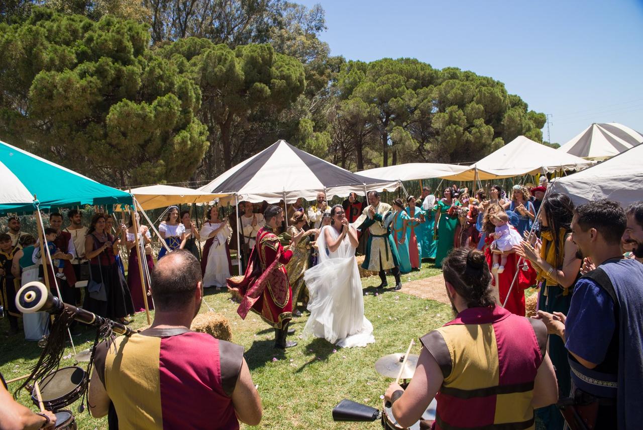 bodas medievales: baile de pareja entre tiendas medievales en un jardín