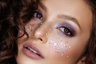 Glitter en la cara con sombras de ojos festivas