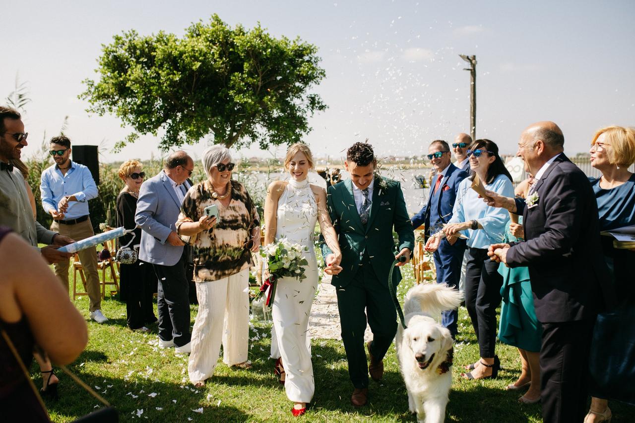 Perros bodas: recién casados bajo una lluvia de pétalos de flores y confeti en compañía de su perro