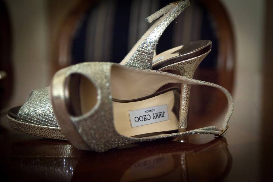 zapatos de novia, de Jimmy Choo, de salón brillantes en purpurina de color plata con uno de ellos tumbado