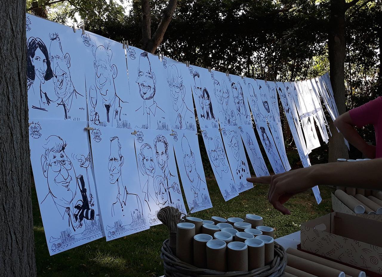 cuerda sujeta entre dos árboles con caricaturas en blanco y negro colgadas con pinzas