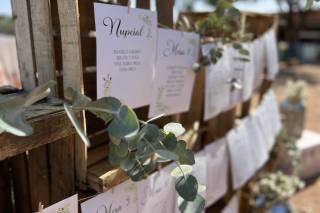 Seating plan original de boda con cajas de madera reciclada y hojas con los nombres de los invitados impresos