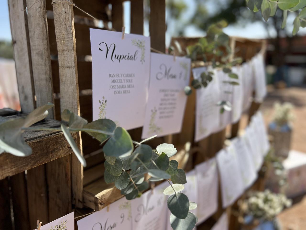 Seating plan original de boda con cajas de madera reciclada y hojas con los nombres de los invitados impresos