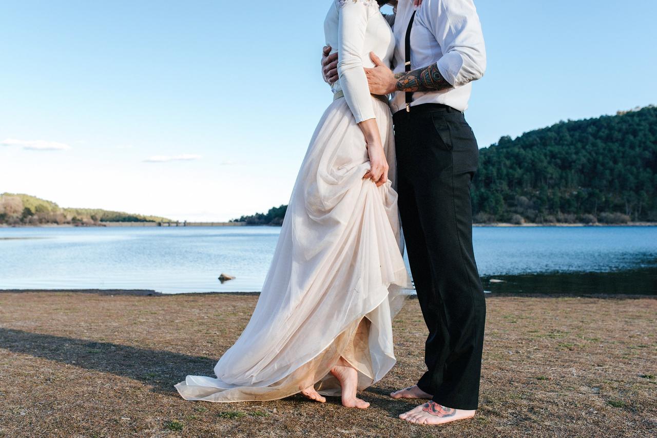 pareja de novios jóvenes descalzos al aire libre en la sesión fotográfica de la boda