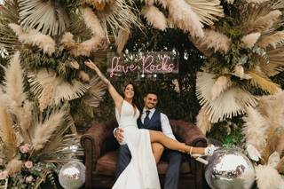 Ideas photocall boda con sofá marrón, hierba de la pampa, neón y bolas de discoteca