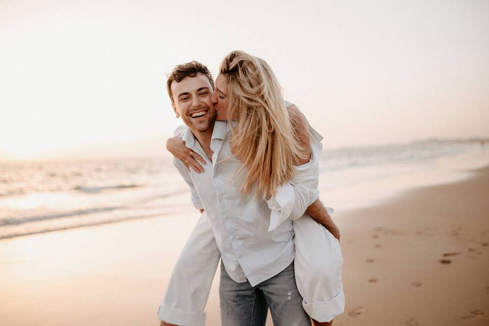 Chica subida a caballito de un chico en la playa le da un beso en la mejilla - que edad prefieren de los hombres las mujeres