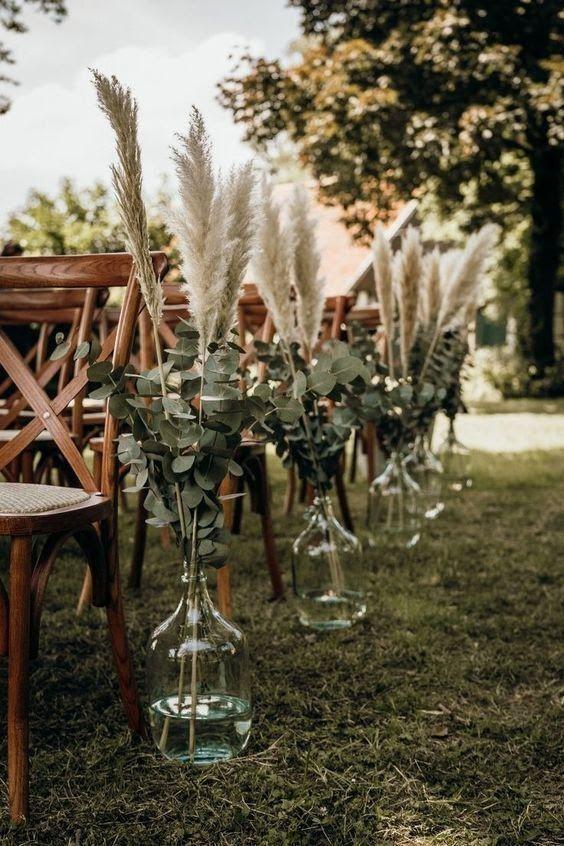 Decoración boda exterior: precioso exterior con sillas de madera y jarrones de cristal transparente con hierba de la pampa en su interior