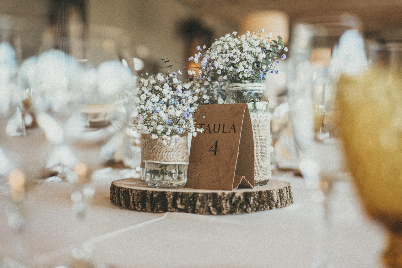 Bodas sencillas: centro de mesa con tronco de madera y jarroncitos con paniculata y número de mesa