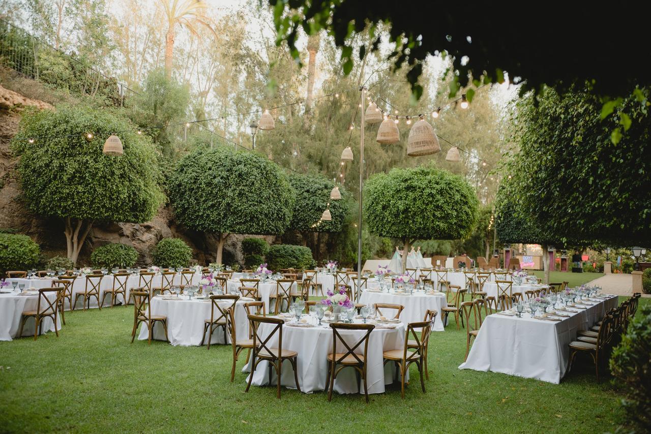 Decoración mesa boda con sillas de madera y lámparas de suspensión