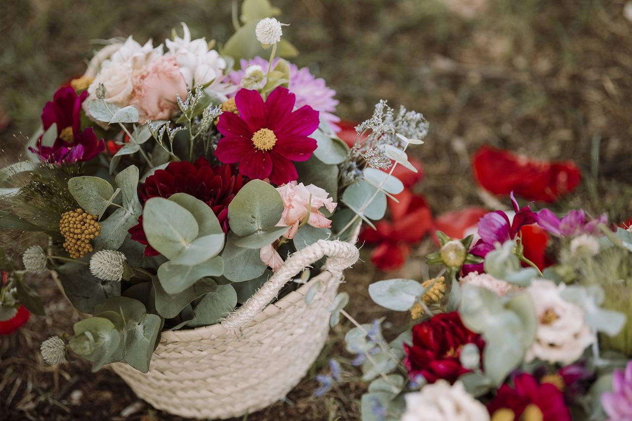 Decoración boda exterior: cesto de fibras vegetales llenos de flores y hojas verdes