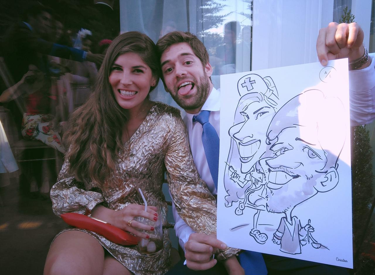 Pareja joven de chico y chica sonriendo con una caricatura de pareja en la mano de él