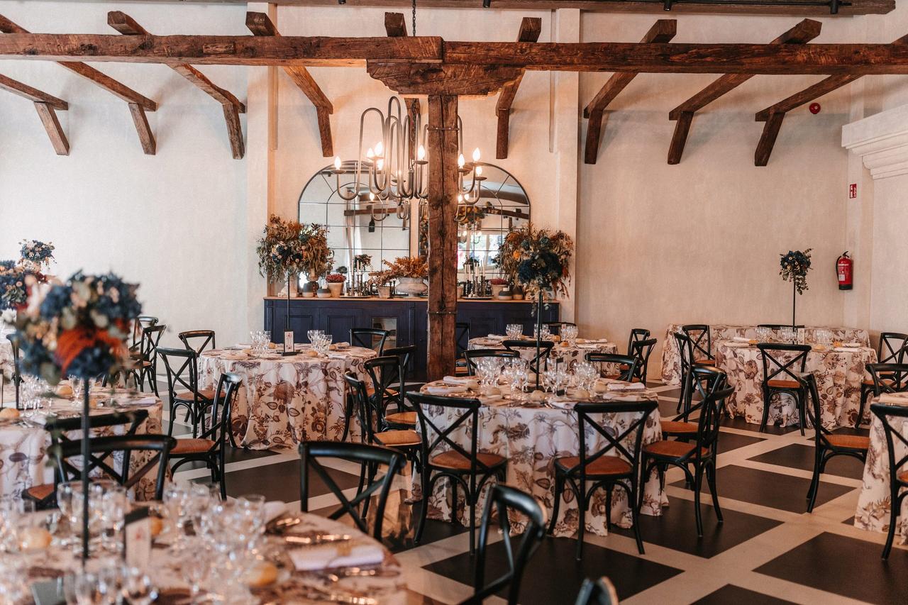 Montaje de mesas circulares en un salón de estilo rústico con vigas de madera