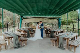 Boda rústica: pareja en el espacio preparado para su banquete de boda