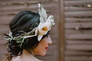 Chica de espalda con un vestido blanco con una corona de flores naturales en la cabeza