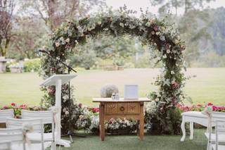 Arco de flores redondo que hace las veces de altar de una boda civil al aire libre