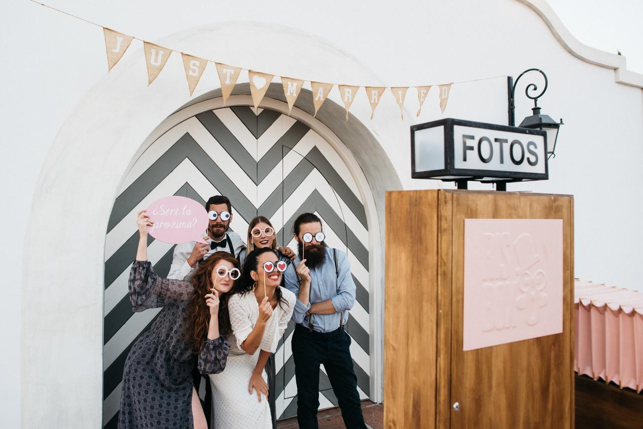 animadores de bodas: invitados posan frente a un fotomatón con accesorios divertidos