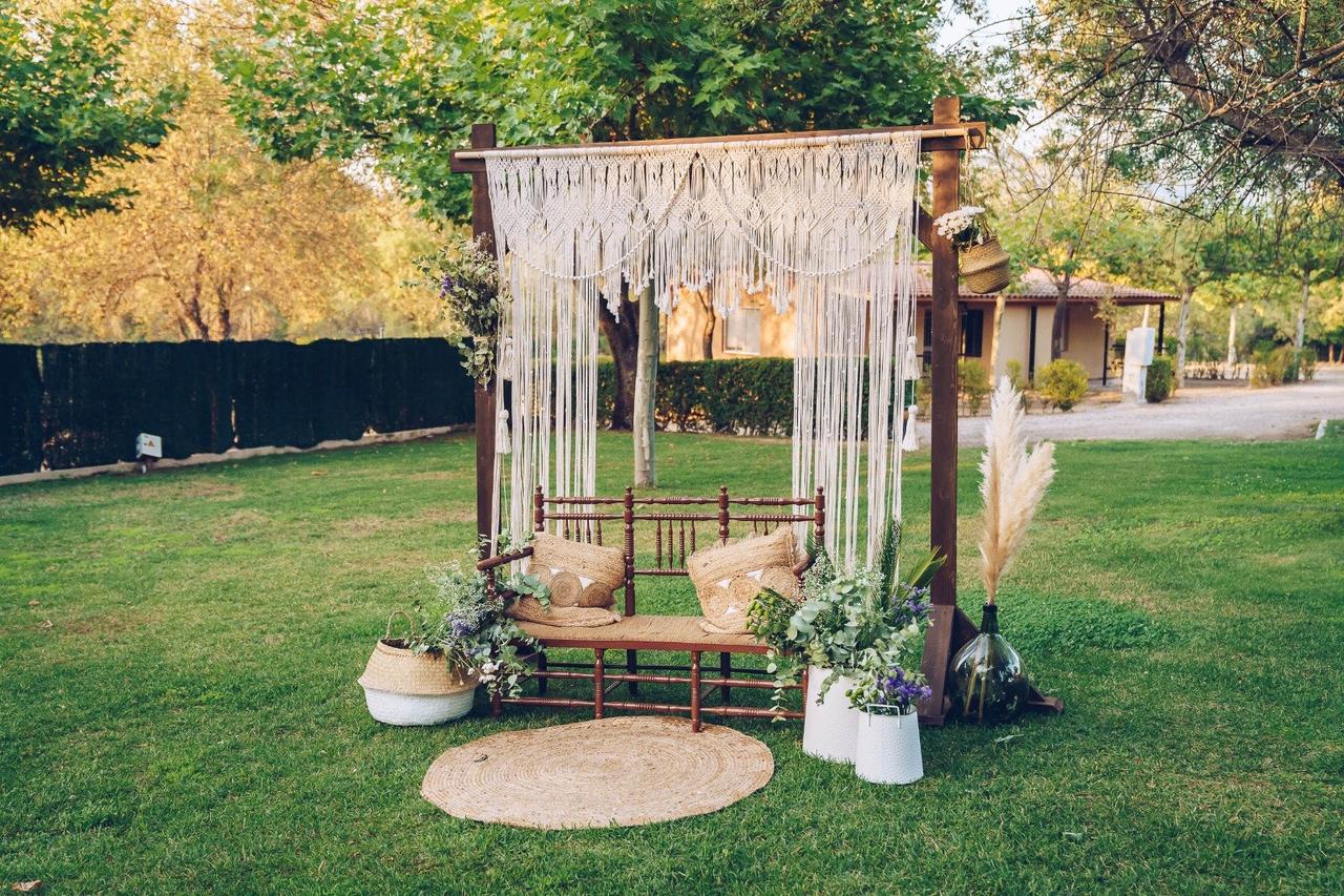 Photocall para bodas: escenario con banco y estructura de madera con macramé