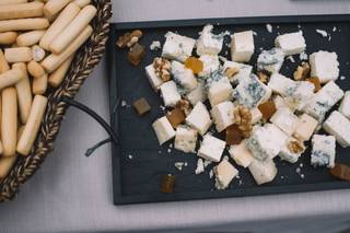 Mesa de quesos boda: distintos tipos de quesos cortados en dados con membrillo