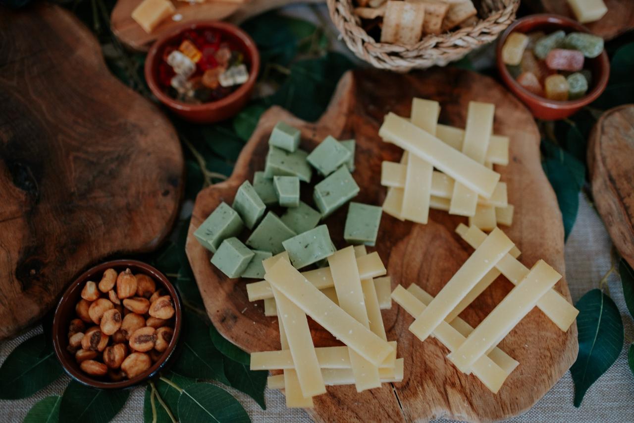 Mesa de quesos boda: distintos tipos de quesos cortados en tiras y en dados y acompañados de algunas chucherías