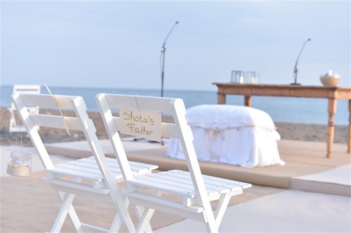 Sillas blancas plegables para una ceremonia civil en la playa