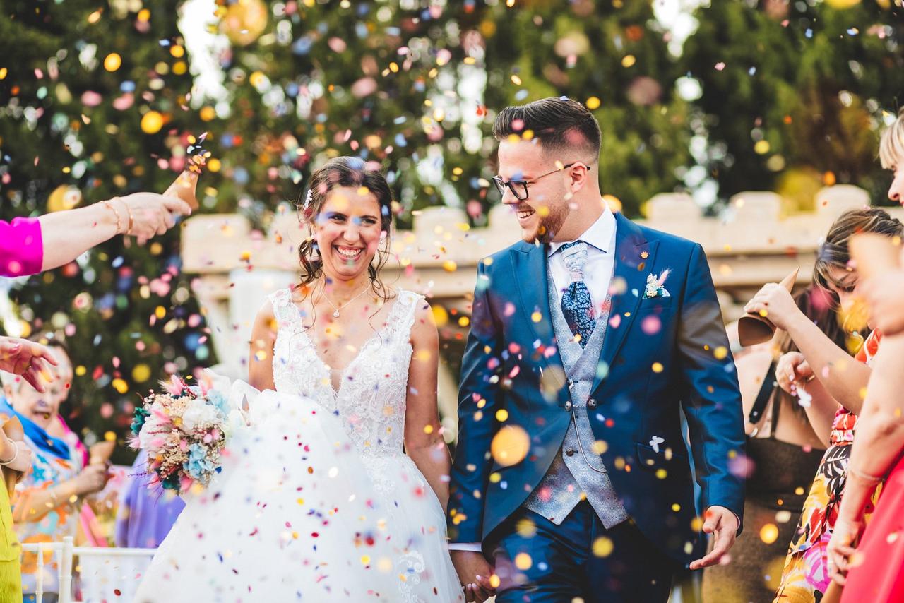 Canciones salida novios: recién casados camina por el pasillo de su boda civil cogidos de la manos bajo una lluvia de confeti