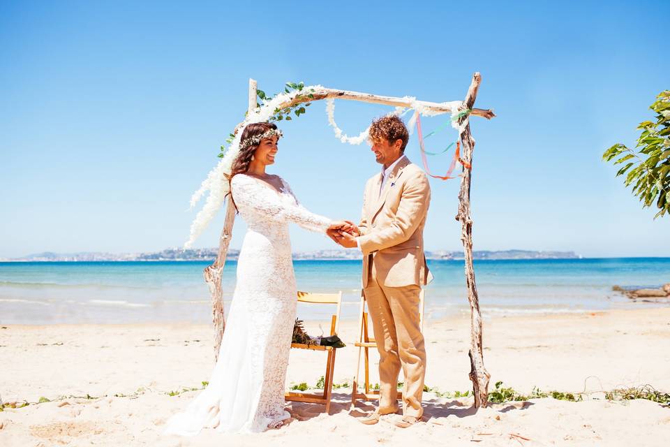 Pareja de novios frente al mar durante su boda en la playa