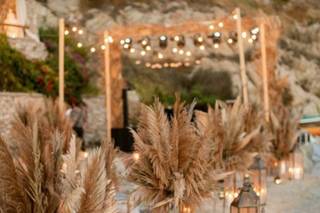 Hieba de la pampa y farolillos metálicos decoran un rincón de celebración de una boda en la playa