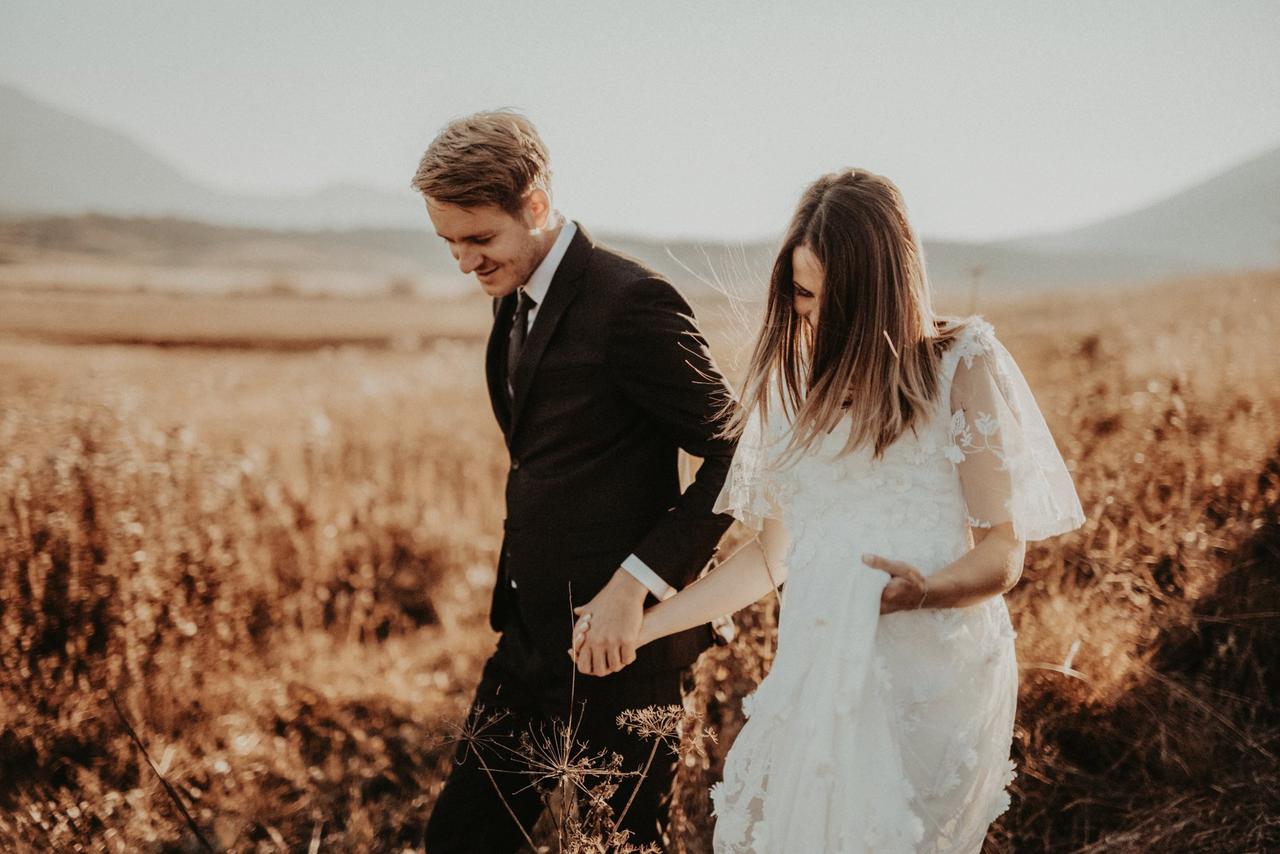 Pareja de novios el día de la boda en medio de un campo de trigo