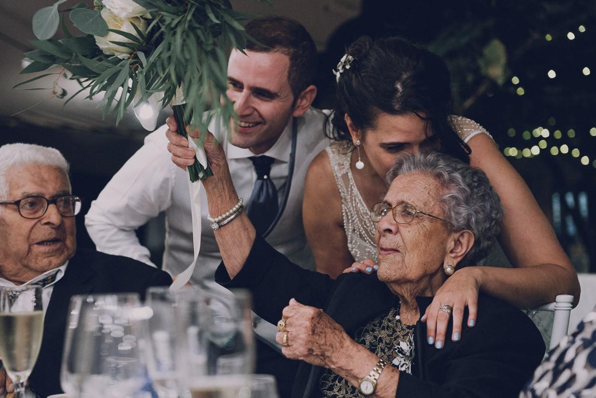 Pareja con sus abuelos después de regalarle el ramo a la abuela el día de la boda