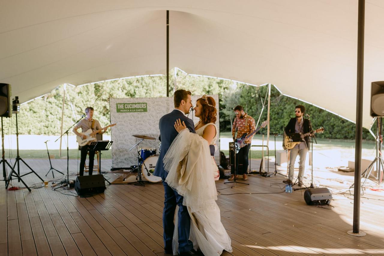 Grupo The Cucumbers tocando en una carpa de boda con la pareja de novios bailando en primer término