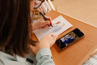 Live painting: manos de mujer pintando la ilustración de una pareja