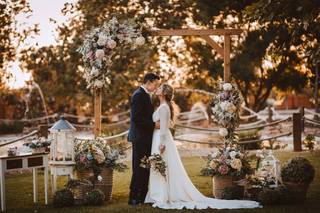 Pareja de recién casados en el altar de su ceremonia civil lleno de flores