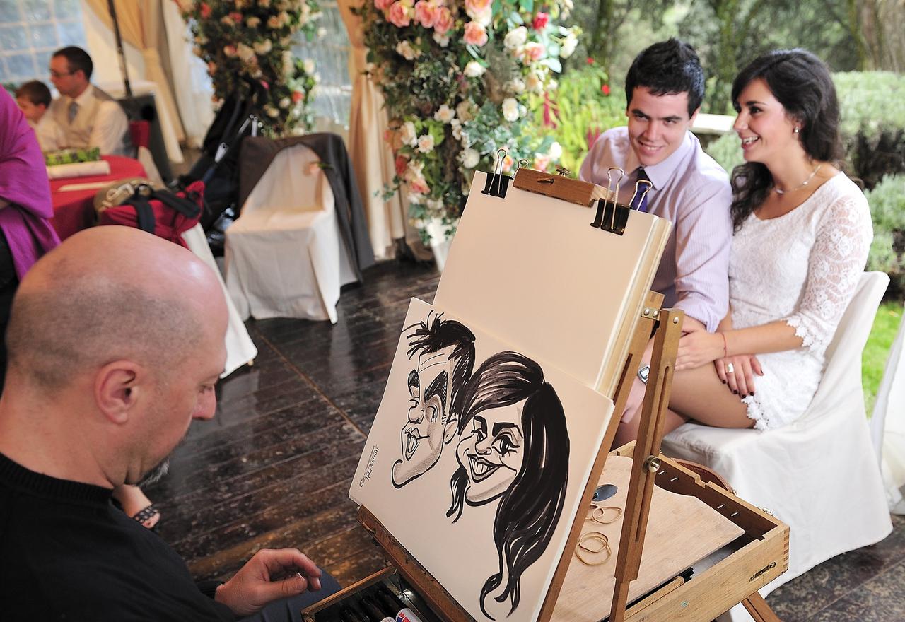 Una pareja haciéndose una caricatura en el día de su boda