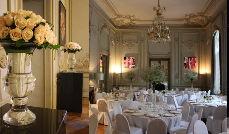 Interior de un salón de estilo clásico con molduras en el techo y las paredes, y preparado para una comida o cena importante