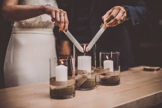 Pareja enciende en el altar una vela mientras realizan la ceremonia de las velas de boda