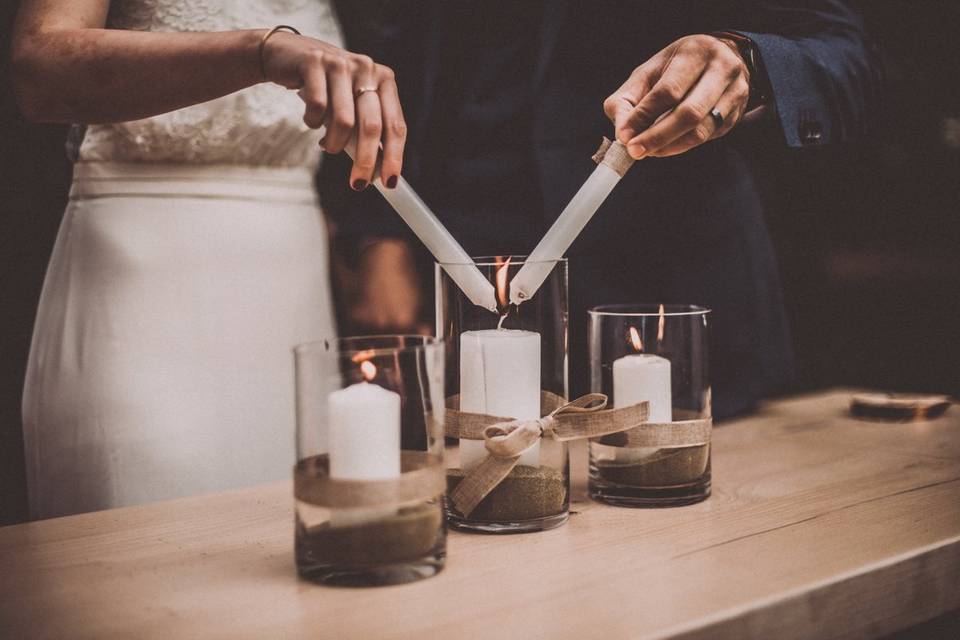 Pareja enciende en el altar una vela mientras realizan la ceremonia de las velas de boda